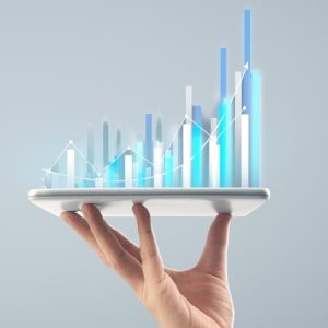 Hand holding tablet with bar graph rising out of it