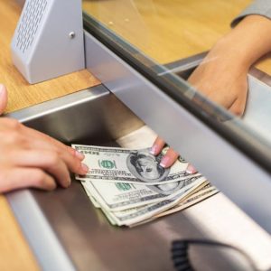 Person receiving cash from bank teller
